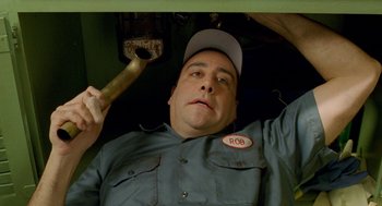 Movie still from “Stuart Little 2” (2002), directed by Rob Minkoff – A man holding a wrench in a garage; Close Up shot, Overhead angle