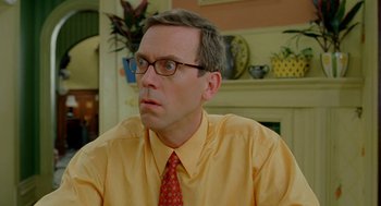 Movie still from “Stuart Little 2” (2002), directed by Rob Minkoff – A man in a yellow shirt and a red tie; Close Up shot, Over the shoulder angle