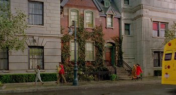 Movie still from “Stuart Little 2” (2002), directed by Rob Minkoff – A woman sweeping the sidewalk in front of a house; Extreme Wide shot, High angle
