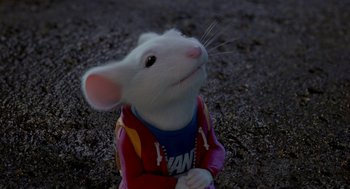 Movie still from “Stuart Little 2” (2002), directed by Rob Minkoff – A white mouse wearing a red jacket and a blue t - shirt; Close Up shot, High angle