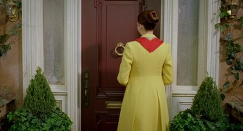 Movie still from “Stuart Little 2” (2002), directed by Rob Minkoff – A woman in a yellow dress standing in front of a door; Medium shot, Over the shoulder angle