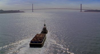 Movie still from “Stuart Little 2” (2002), directed by Rob Minkoff – A large barge in the middle of the ocean near a bridge; Extreme Wide shot, High angle