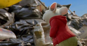 Movie still from “Stuart Little 2” (2002), directed by Rob Minkoff – A white rabbit wearing a red jacket standing next to a pile of rubble; Medium shot, Over the shoulder angle