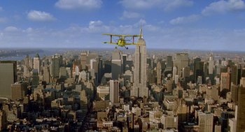 Movie still from “Stuart Little 2” (2002), directed by Rob Minkoff – An airplane flying over a large city with skyscrapers in the background; Extreme Wide shot, High angle