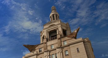 Movie still from “Stuart Little 2” (2002), directed by Rob Minkoff – A large building with wings on the top of the building; Extreme Wide shot, Low angle