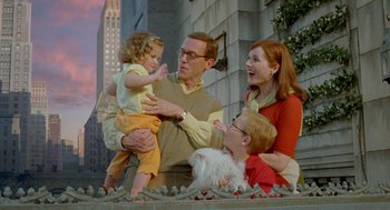Movie still from “Stuart Little 2” (2002), directed by Rob Minkoff – A man holding a child while a woman and a little girl look on; Medium shot, Low angle