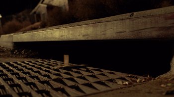 Movie still from “Breaking Bad” (2008), created by Vince Gilligan – A piece of wood on a metal floor; Wide shot, Overhead angle