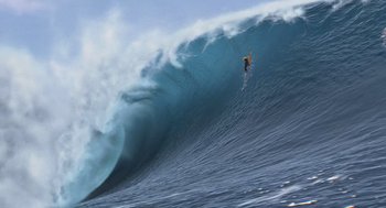 Movie still from “Surf's Up” (2007), directed by Chris Buck – A man riding a wave on top of a surfboard in the ocean; Extreme Wide shot, Low angle