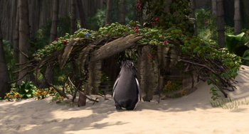 Movie still from “Surf's Up” (2007), directed by Chris Buck – A penguin standing in the sand near a tree; Wide shot, High angle