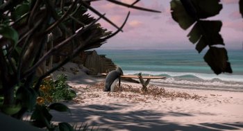 Movie still from “Surf's Up” (2007), directed by Chris Buck – A surfboard sitting on top of a sandy beach next to the ocean; Wide shot, High angle