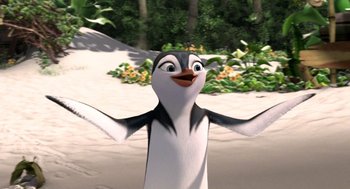 Movie still from “Surf's Up” (2007), directed by Chris Buck – A penguin is standing in the sand with his arms outstretched; Close Up shot, Low angle