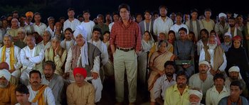 A group of people sitting in a room with a man standing in front of them