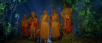 Movie still from “Swades” (2004), directed by Ashutosh Gowariker – A group of men in traditional costumes standing next to each other in front of a tree; Wide shot, Low angle