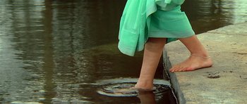 Movie still from “Swades” (2004), directed by Ashutosh Gowariker – A woman in a green dress standing in a body of water; Extreme Close Up shot, High angle