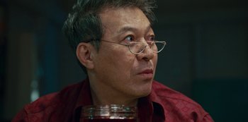 Movie still from “Sweet Home” (2020), directed by Eung Bok Lee – An older man wearing glasses and a red shirt is holding a jar; Close Up shot, Low angle