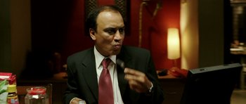 Movie still from “Like Stars on Earth” (2007), directed by Aamir Khan – A man wearing a suit and tie holding a spoon in his mouth; Close Up shot, Low angle