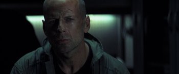 A man with a shaved head is looking at the camera