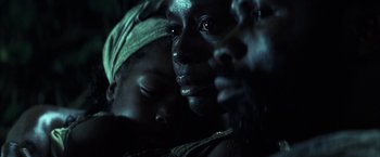 Movie still from “Tears of the Sun” (2003), directed by Antoine Fuqua – A woman and a child in a dimly - lit room; Extreme Close Up shot, High angle