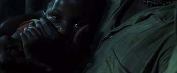 Movie still from “Tears of the Sun” (2003), directed by Antoine Fuqua – A person with a cell phone to their ear; Extreme Close Up shot, High angle