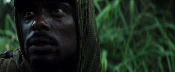 Movie still from “Tears of the Sun” (2003), directed by Antoine Fuqua – A man's face with a hood on; Close Up shot, Low angle