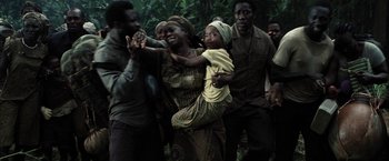 Movie still from “Tears of the Sun” (2003), directed by Antoine Fuqua – A group of people standing around each other in the woods; Medium shot, High angle