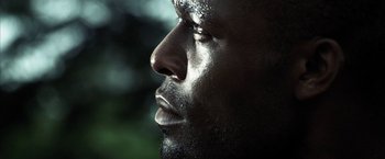 Movie still from “Tears of the Sun” (2003), directed by Antoine Fuqua – A man's face in the sunlight; Extreme Close Up shot, Low angle