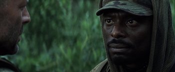 Movie still from “Tears of the Sun” (2003), directed by Antoine Fuqua – A person wearing a hat; Close Up shot, Over the shoulder angle