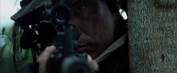 Movie still from “Tears of the Sun” (2003), directed by Antoine Fuqua – A person holding a gun; Close Up shot, Over the shoulder angle