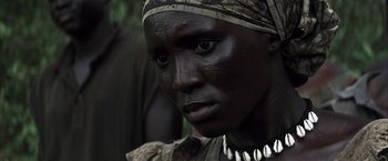 Movie still from “Tears of the Sun” (2003), directed by Antoine Fuqua – A person with a black head covering and a necklace; Close Up shot, High angle