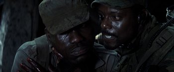Movie still from “Tears of the Sun” (2003), directed by Antoine Fuqua – Two black men are talking to each other; Close Up shot, Over the shoulder angle