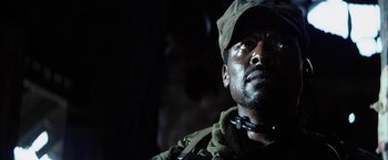 Movie still from “Tears of the Sun” (2003), directed by Antoine Fuqua – A man in a military uniform looking up at the sky; Close Up shot, Low angle