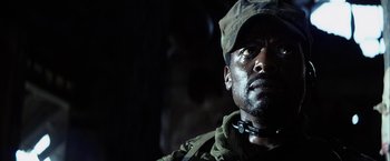 Movie still from “Tears of the Sun” (2003), directed by Antoine Fuqua – A man in a military uniform looking at the camera; Close Up shot, Low angle