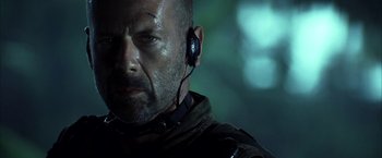 Movie still from “Tears of the Sun” (2003), directed by Antoine Fuqua – A man with a beard wearing a pair of ear phones; Close Up shot, Low angle