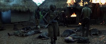 Movie still from “Tears of the Sun” (2003), directed by Antoine Fuqua – A woman holding a rifle in front of a group of dead animals; Wide shot, High angle