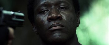 Movie still from “Tears of the Sun” (2003), directed by Antoine Fuqua – A man's face with dark skin; Close Up shot, Low angle