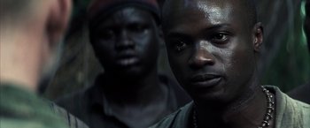 Movie still from “Tears of the Sun” (2003), directed by Antoine Fuqua – Two black men standing next to each other in a dark room; Close Up shot, Low angle