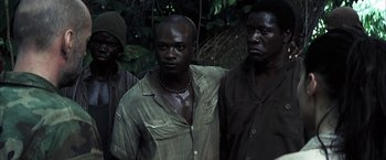 Movie still from “Tears of the Sun” (2003), directed by Antoine Fuqua – A group of men standing next to each other in a forest; Medium shot, High angle