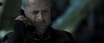 Movie still from “Tears of the Sun” (2003), directed by Antoine Fuqua – A bald man with a headset on looking at the camera; Close Up shot, Low angle