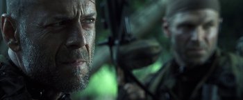 Movie still from “Tears of the Sun” (2003), directed by Antoine Fuqua – A person holding a gun; Close Up shot, Low angle