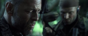 Movie still from “Tears of the Sun” (2003), directed by Antoine Fuqua – A man's face in a wooded area; Close Up shot, Over the shoulder angle