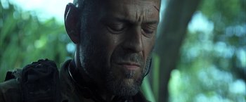 Movie still from “Tears of the Sun” (2003), directed by Antoine Fuqua – A person with a beard looking down; Close Up shot, Low angle