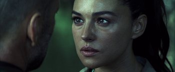 Movie still from “Tears of the Sun” (2003), directed by Antoine Fuqua – A woman's face in a forest setting; Close Up shot, Over the shoulder angle