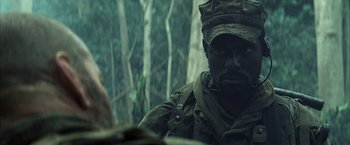 Movie still from “Tears of the Sun” (2003), directed by Antoine Fuqua – A man in a military uniform is looking at the camera; Close Up shot, Over the shoulder angle