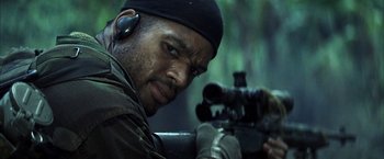 Movie still from “Tears of the Sun” (2003), directed by Antoine Fuqua – A man with a rifle in the woods; Close Up shot, Over the shoulder angle