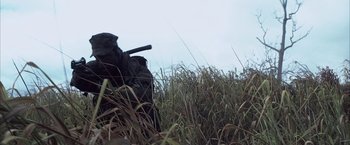 A person in a field with a gun