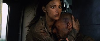 Movie still from “Tears of the Sun” (2003), directed by Antoine Fuqua – A man and a woman are hugging in a dark room; Close Up shot, Overhead angle