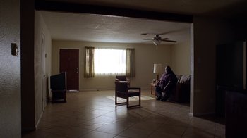 Movie still from “Breaking Bad” (2008), created by Vince Gilligan – A person sitting on a couch in a living room; Extreme Wide shot, High angle