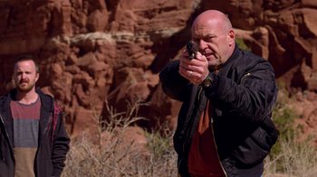 Movie still from “Breaking Bad” (2008), created by Vince Gilligan – A man holding a gun in his hand; Medium shot, Low angle