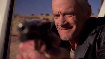 Movie still from “Breaking Bad” (2008), created by Vince Gilligan – An older man is holding a gun in his hand; Close Up shot, Low angle