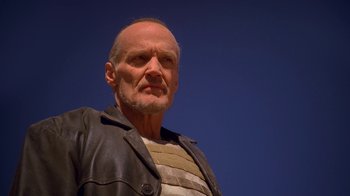 Movie still from “Breaking Bad” (2008), created by Vince Gilligan – An older man wearing a leather jacket and striped shirt; Close Up shot, Low angle